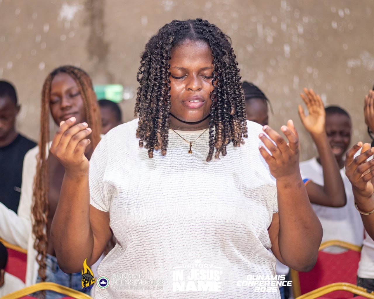 A teenager worshipping with her hands raised